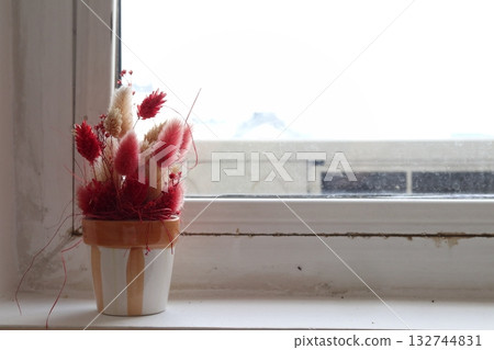 Pots with artificial flowers on the windowsill. 132744831