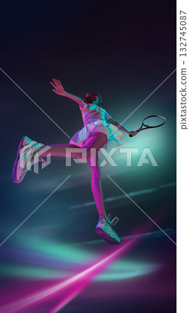 Female tennis player jumping forward in bright neon light with emotion Female tennis player jumping forward in bright neon light with emotion 132745087