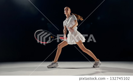 Female tennis player standing wide stance ready position indoor arena light 132745102