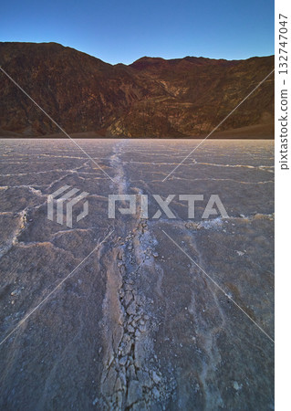 Cracked Salt Flats and Rugged Mountains at Badwater Basin in Nevada Under Blue Sky Cracked Salt Flats and Rugged Mountains at Badwater Basin in Nevada Under Blue Sky 132747047