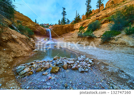 Waterfall and Rocky Stream at Mossy Cave Trail with Colorful Cliffs and Lush Greenery Waterfall and Rocky Stream at Mossy Cave Trail with Colorful Cliffs and Lush Greenery 132747160