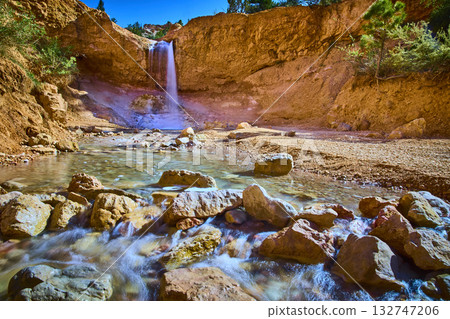 Waterfall Flowing Over Red Cliffs and Rocky Stream in Utah Desert Canyon 132747206