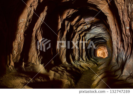Sandstone Tunnel Passage with Carved Walls and Light Filled Exit 132747289