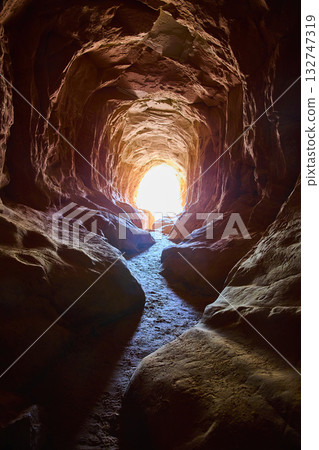 Belly of the Dragon Cave Tunnel Interior with Sunlit Exit Trail Utah 132747319