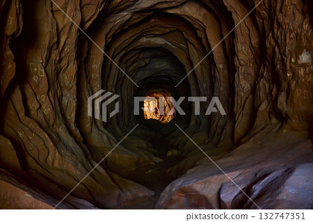 Hand Carved Desert Tunnel with Graffiti and Sunlit Exit Belly of the Dragon Utah 132747351