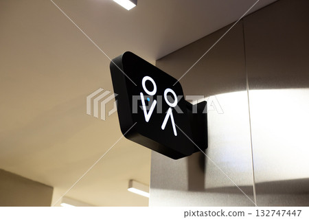 The entrance to men and women restrooms is marked with universal signs for easy identification. Sign on the wall indicates the restroom. Public hygiene concept. Modern restroom interior The entrance to men and women restrooms is marked with universal signs for easy identification. Sign on the wall indicates the restroom. Public hygiene concept. Modern restroom interior 132747447