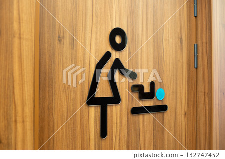 Black lines form the symbol of mother changing her baby diaper. Entrance to the diaper changing room. Concept for accessible public environment for parents 132747452