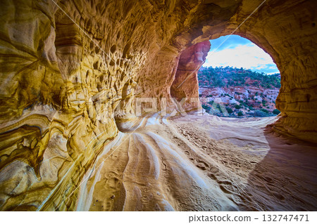 Sandstone Cave Interior with Footprints and Desert Landscape Framed Opening 132747471