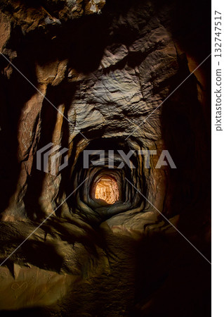Rugged Rock Tunnel Interior with Warm Light and Graffiti Belly of the Dragon Cave Rugged Rock Tunnel Interior with Warm Light and Graffiti Belly of the Dragon Cave 132747517