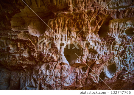Sandstone Cave Wall Texture with Ancient Carvings and Natural Erosion Patterns Sandstone Cave Wall Texture with Ancient Carvings and Natural Erosion Patterns 132747766