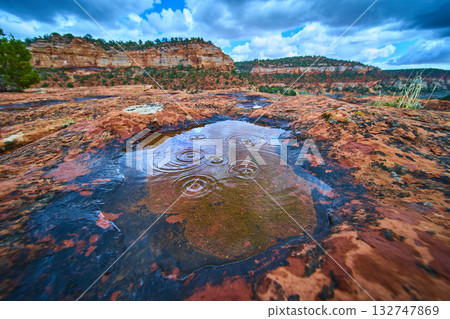 Rainwater Pool on Red Sandstone with Ripples and Lichen in Desert Close Up 132747869