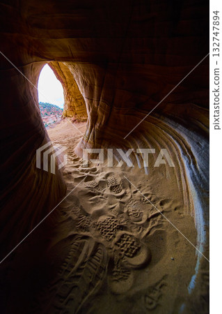 Sandstone Cave Interior with Footprints and Sunlit Desert Opening Kanab Utah Sandstone Cave Interior with Footprints and Sunlit Desert Opening Kanab Utah 132747894