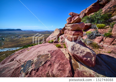 Rock Stack Cairn on Red Rock Outcrop with Desert Valley and Blue Sky 132748088