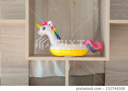 inflatable unicorn toy on a wooden shelf inflatable unicorn toy on a wooden shelf 132748308