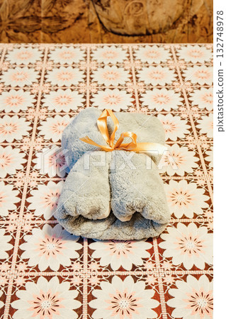 rolled-up towel with a gift ribbon on the table rolled-up towel with a gift ribbon on the table 132748978