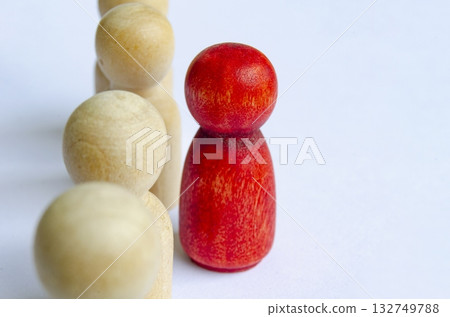 Red wooden peg standing out from the rest representing courage or speakup Red wooden peg standing out from the rest representing courage or speakup 132749788