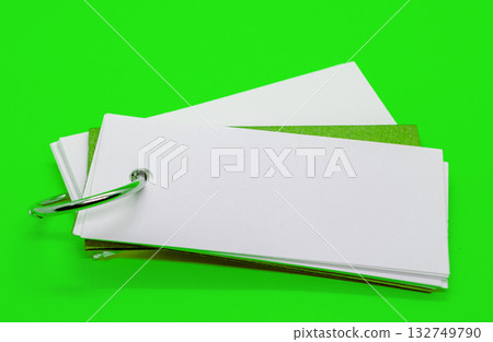 Close up of white banner shape notepad with customizable space for text on green cover background. Copy space concept. Close up of white banner shape notepad with customizable space for text on green cover background. Copy space concept. 132749790
