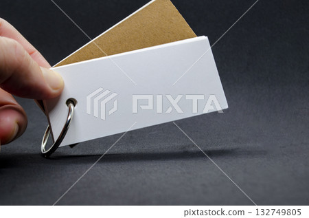 White banner shape notepad with customizable space for text on dark background. White banner shape notepad with customizable space for text on dark background. 132749805