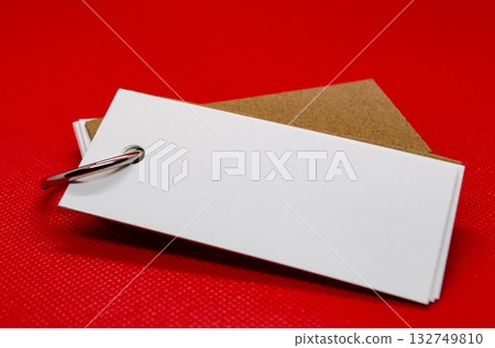 Close up of white banner shape notepad with customizable space for text on red cover background. Copy space concept. 132749810