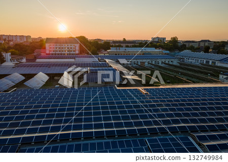 Aerial view of blue photovoltaic solar panels mounted on industrial building roof for producing green ecological electricity. Production of sustainable energy concept 132749984