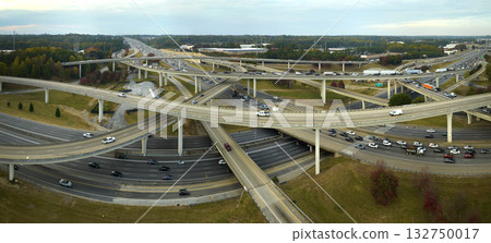 Aerial view of american freeway intersection with fast moving cars and trucks. USA transportation infrastructure concept Aerial view of american freeway intersection with fast moving cars and trucks. USA transportation infrastructure concept 132750017
