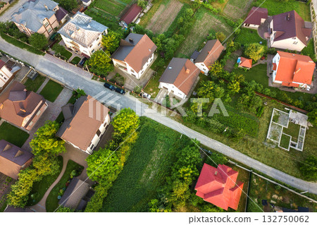 Aerial landscape of small town or village with rows of residential homes and green trees. Aerial landscape of small town or village with rows of residential homes and green trees. 132750062