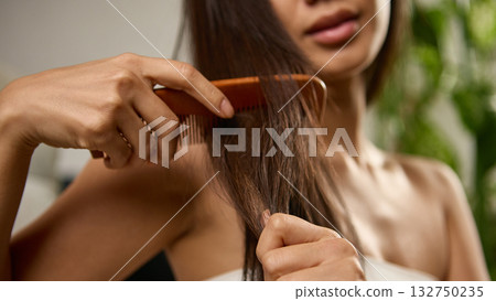 Close view of woman combing hair showing strength softness and health Close view of woman combing hair showing strength softness and health 132750235
