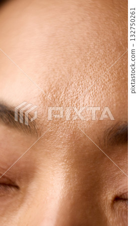 Close macro of forehead skin showing texture moisture and light balance 132750261