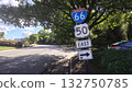 The road sign located in the shade of a tree has four signs, where the first two indicate that the road leads interstate, and the second two indicate that a right turn is only possible 132750785