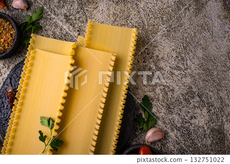 Uncooked lasagna pasta with cooking ingredient Uncooked lasagna pasta with cooking ingredient 132751022