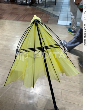 磁磚地板上的破損黃色雨傘 磁磚地板上的破損黃色雨傘 132751305