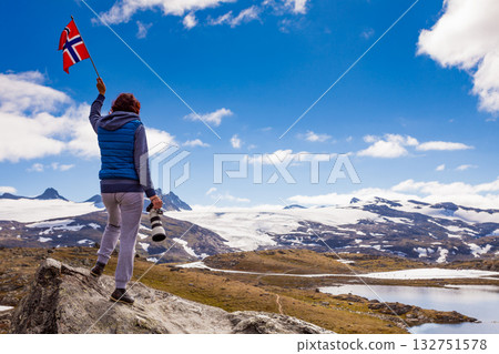 Tourist with camera and flag in Norway mountains Tourist with camera and flag in Norway mountains 132751578