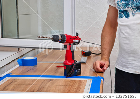 repairman using electric drill and installation new modern kitchen 132751655