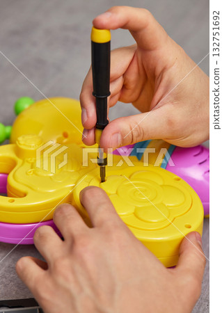 Father repairing toy using screwdriver at home Father repairing toy using screwdriver at home 132751692