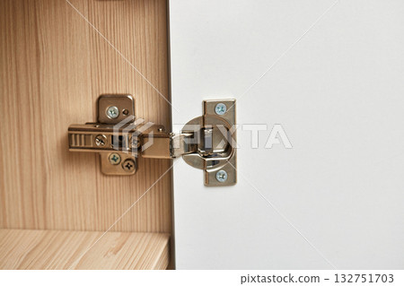 Modern and adjustable silver cabinet door hinges for furniture , with visible screws and hinge mechanism, close-up Modern and adjustable silver cabinet door hinges for furniture , with visible screws and hinge mechanism, close-up 132751703