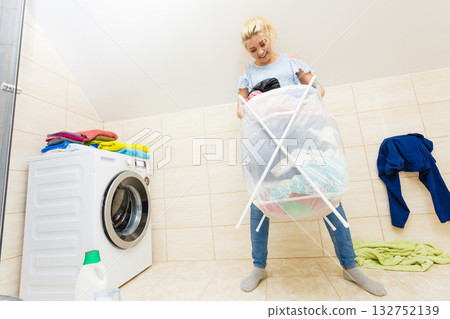 Woman carry big basket of dirty clothes laundry. Woman carry big basket of dirty clothes laundry. 132752139