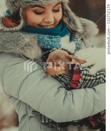 Woman hug warming her little dog in winter 132752174