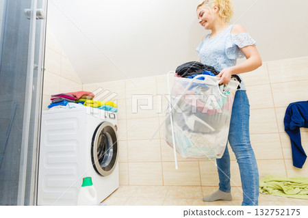 Woman carry big basket of dirty clothes laundry. Woman carry big basket of dirty clothes laundry. 132752175