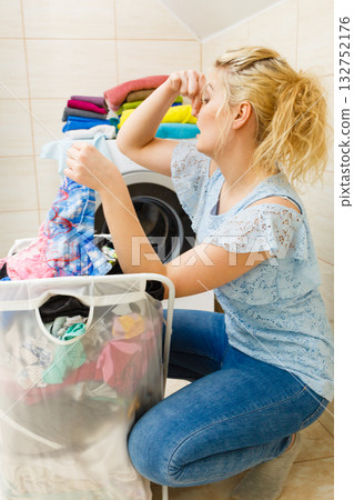 Unhappy girl with dirty clothes laundry. 132752176