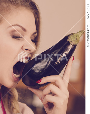 Woman holding biting eggplant. Woman holding biting eggplant. 132752475