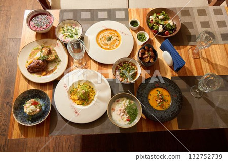 An Exquisite Dining Experience Featuring Varied Dishes Presented on a Rustic Table An Exquisite Dining Experience Featuring Varied Dishes Presented on a Rustic Table 132752739