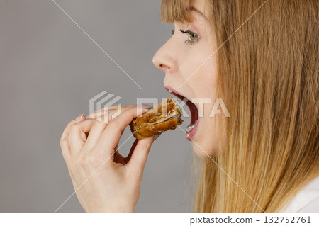 Woman eating sandwich, taking bite 132752761