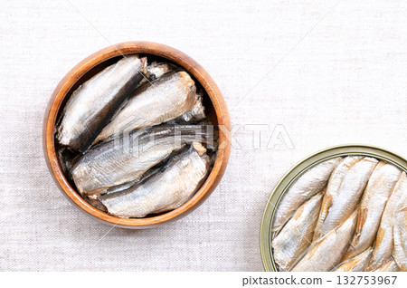 Sardines, with skin and bones, in vegetable oil, in a wooden bowl, on linen. Canned, wild caught sardines, or pilchards, Sardina pilchardus, a small and oily fish, and source of omega-3 fatty acids. 132753967
