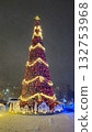 Illuminated Christmas Tree on a city street at winter night during a snowstorm 132753968