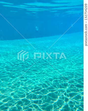 Close-up of the water of a swimming pool with the sunlight reflection. The scene of the swimming pool in the sunny day. Relaxation and holiday concept. 132754209