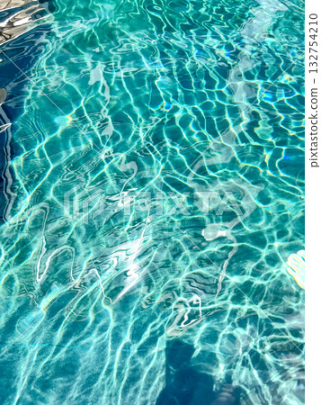 Close-up of the water of a swimming pool with the sunlight reflection. The scene of the swimming pool in the sunny day. Relaxation and holiday concept. Close-up of the water of a swimming pool with the sunlight reflection. The scene of the swimming pool in the sunny day. Relaxation and holiday concept. 132754210