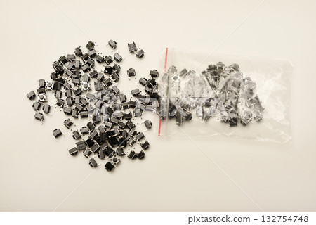 Black electronic buttons in a plastic bag. Electronic elements. Black electronic buttons in a plastic bag. Electronic elements. 132754748
