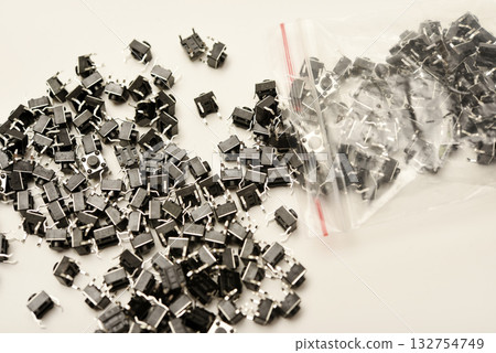 Black electronic buttons in a plastic bag. Electronic elements. Black electronic buttons in a plastic bag. Electronic elements. 132754749