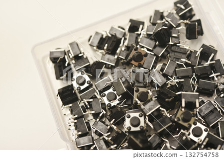Black electronic buttons in a plastic container. Electronic elements. 132754758