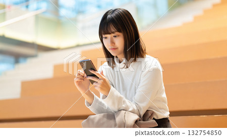 Women and businesswomen using smartphones Women and businesswomen using smartphones 132754850